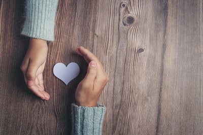 paper-heart-couple-s-hands-wooden-table_1150-26178